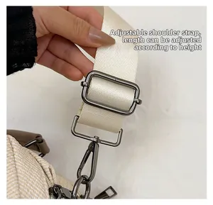 Close-up of adjustable woven shoulder strap with metallic hardware on beige square bag