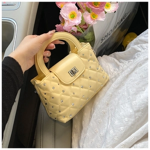 Detail of yellow quilted handbag with rhinestones on a car seat with flowers