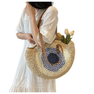 Large hand-woven straw tote bag with blue eye pattern and brown leather straps