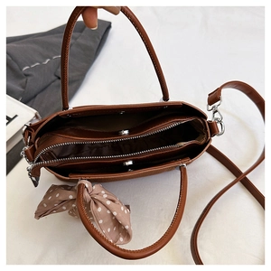 Vue intérieure du sac en cuir marron montrant les compartiments et le foulard en soie