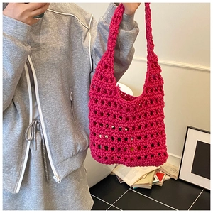Detail of fuchsia handmade crochet shoulder bag with hollow knit grid and thick cord texture