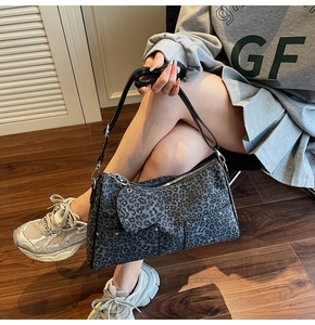 Dettaglio della borsa tote leopardata con tasche funzionali e ciondolo a forma di cuore