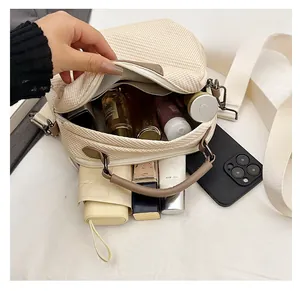 Close-up of the spacious interior of the woven crossbody bag showing large capacity