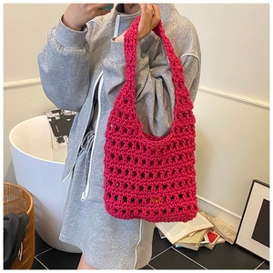 Close-up of a rose red hollow knit tote bag showing intricate crochet weave and texture