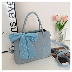 Détail d'un sac à bandoulière bleu clair tissé orné d'un ruban à pois élégant et raffiné