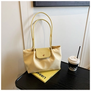 Detail of soft pale yellow faux leather tote bag with magnetic closure and thin straps