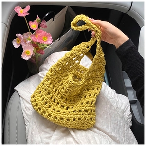 Detail view of yellow crochet tote bag featuring intricate openwork knit texture