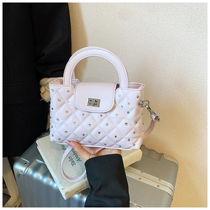 Detailed shot of quilted pink handbag with rhinestone embellishments and silver lock
