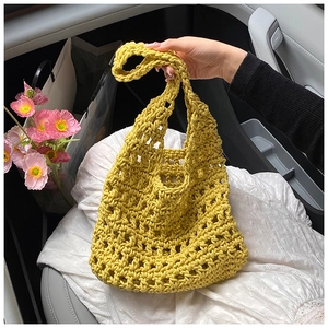 Detail shot of a yellow knit handbag with hollow patterns and thick cotton rope textures