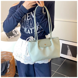 Detail of mint green tote bag with metallic clasp and adjustable double shoulder straps