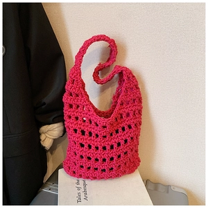 Detail of hot pink hand-knitted tote bag showing intricate hollow crochet texture and weave