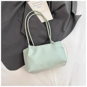 Close-up of mint green large capacity tote bag with long handles on grey blazer