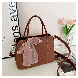 Détail d'un sac cabas en sergé marron avec foulard rose à pois et bandoulière réglable