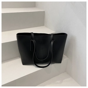 Detailed view of black retro tote bag with vertical stitching on minimalist stairs