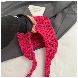 Macro shot of rose red hollow knit bag showing thick cotton weave texture and spacious interior