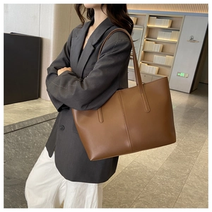 Detail showing side profile of brown leather tote bag with long shoulder straps