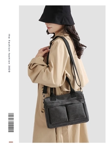Detail of dark grey canvas tote with dual front pockets and adjustable nylon strap