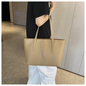 Detailed view of khaki leather tote bag featuring elegant stitching and long handles