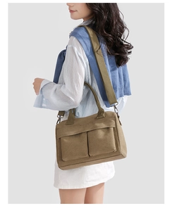 Detail of army green nylon shoulder bag featuring textured fabric and flap pockets