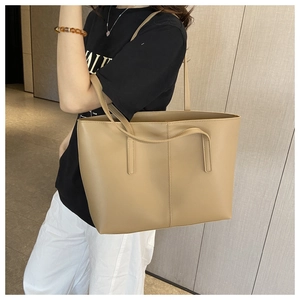 Close-up of tan matte leather tote bag showing large capacity and long handles