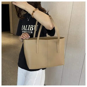 Detail of earthy khaki tote bag with fine leather texture and vertical stitch design
