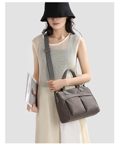 Close-up of large nylon canvas bag featuring double front pockets and wide shoulder strap