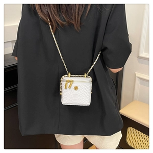 Détail du mini sac blanc effet croco avec fermoir fleur dorée et bandoulière