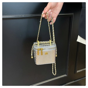 Détail du mini sac boîte argenté à motif serpent avec camélia doré et bandoulière