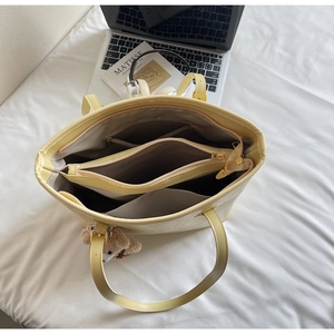 Detailansicht der großen Shopper-Tasche mit Steinstruktur, Reißverschluss und Bärenanhänger