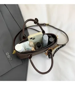 Détail de l'intérieur d'un sac à main marron montrant sa grande capacité de rangement