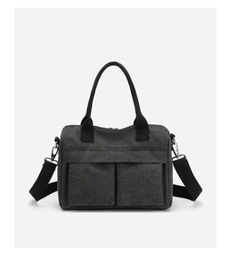 Detail view of charcoal nylon crossbody bag with large front pockets and black straps