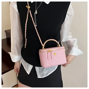 Pink quilted crossbody box bag with gold metal handle and chain strap on a model
