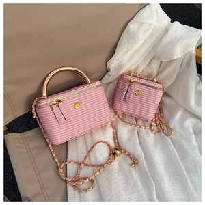 Detailed view of pink woven mini bags with gold camellia hardware and chain straps