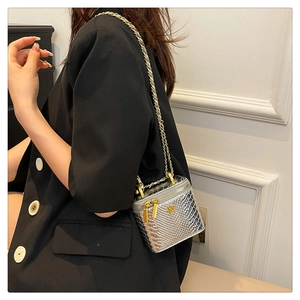 Détail du mini sac boîte argenté à motif crocodile avec fleur dorée et bandoulière