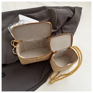Detail of beige woven mini chain bag with gold strap and herringbone fabric lining