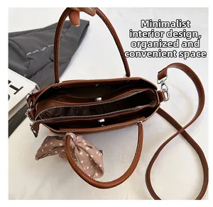 Vue détaillée de l'intérieur du sac en cuir marron avec compartiments et foulard en soie