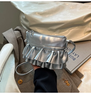 Detail of silver metallic mini bucket bag with double layer ruffle texture and crossbody strap