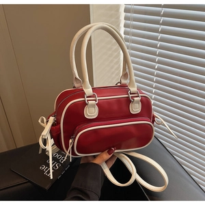 Detail of red and white vintage crossbody bag with curved zipper pocket and handle