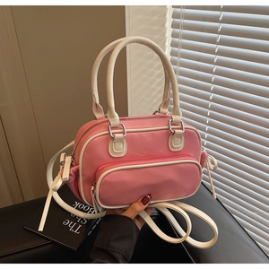 Detail of pink and white crossbody bag with silver hardware and front zipper pocket