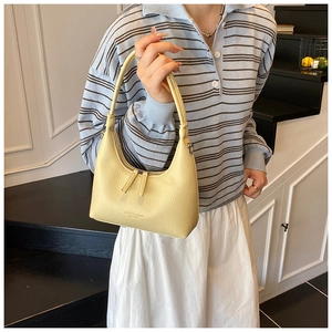 Detail of yellow lychee pattern shoulder bag with dual zipper and metal hardware