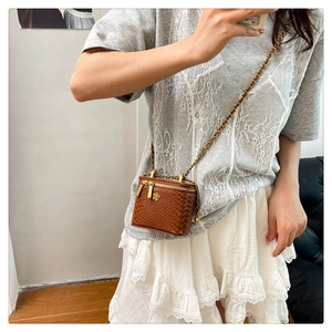 Vue détaillée du mini sac vanity marron à motif crocodile avec fermeture éclair fleurie