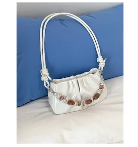 Dettaglio della borsa a nuvola plissettata bianca lucida con catena di perle decorativa