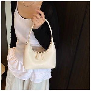 Close-up of cream lychee texture leather hobo bag with knotted handle detail