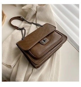 Vue détaillée du sac en similicuir marron foncé avec matelassage en V et fermoir rotatif