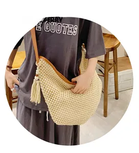 Close-up of beige woven beach bag featuring intricate hollow knit and wooden bead tassel