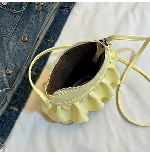 Top view of yellow pleated bucket bag with brown striped lining and silver zipper