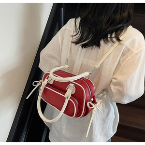Detail of red and cream backpack with side bow ties and dual zipper closures