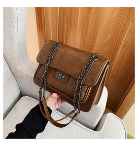 Détails de la texture en cuir matelassé marron et du fermoir rotatif en métal sombre