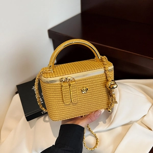 Yellow box-shaped woven chain bag with gold circular handle and camellia ornament