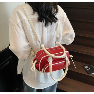 Close-up of a red and white leather convertible backpack shown in a lifestyle indoor setting
